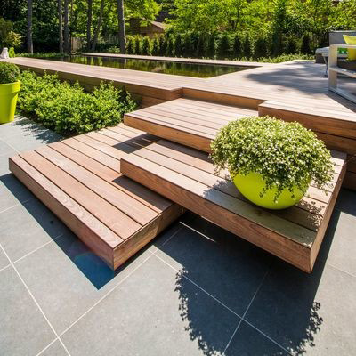 Dit terras in ipé-hout is een vakkundig uitgewerkte puzzel die het zwembad doet ‘overvloeien’ in de tuin.